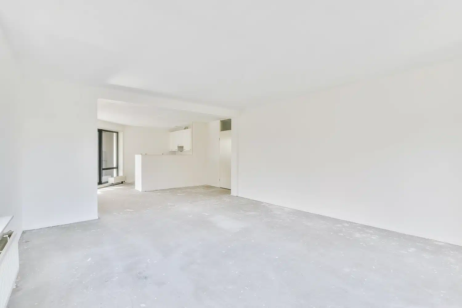 Leerer, frisch renovierter Wohnraum mit durchgehend planer, heller Estrichfläche, bereit für den Bodenbelag.